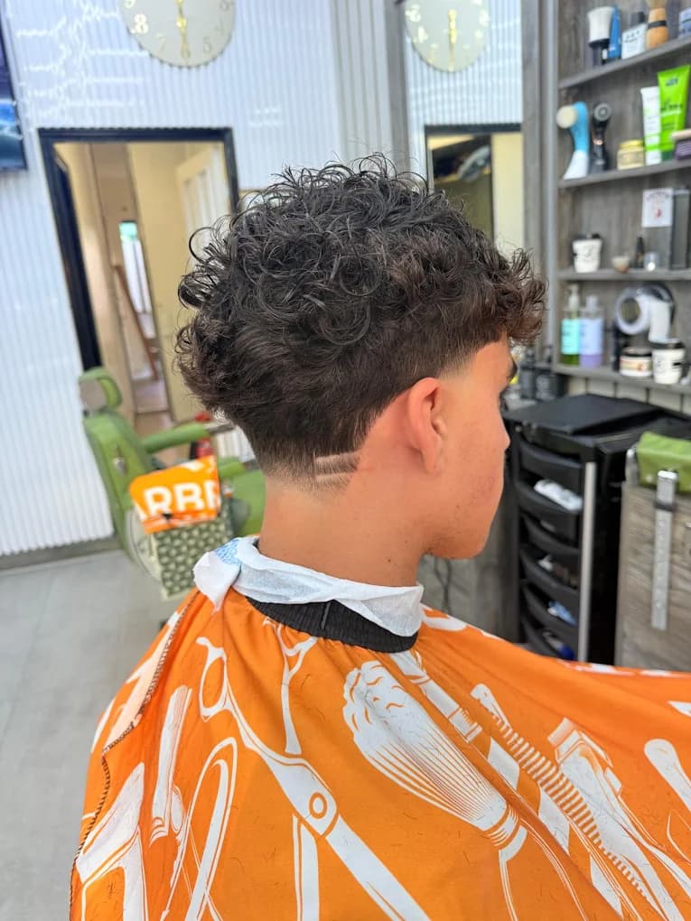 Tapered curly fringe with a double surgical line design on the neckline