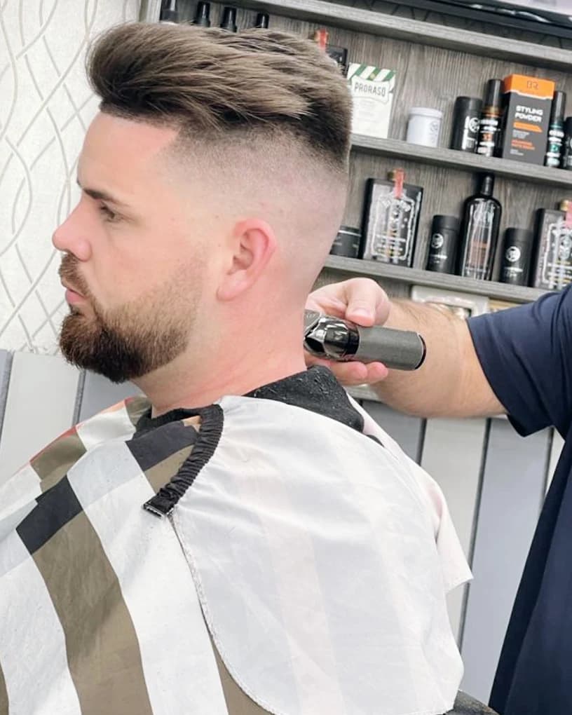 High skin fade with a textured quiff and groomed beard