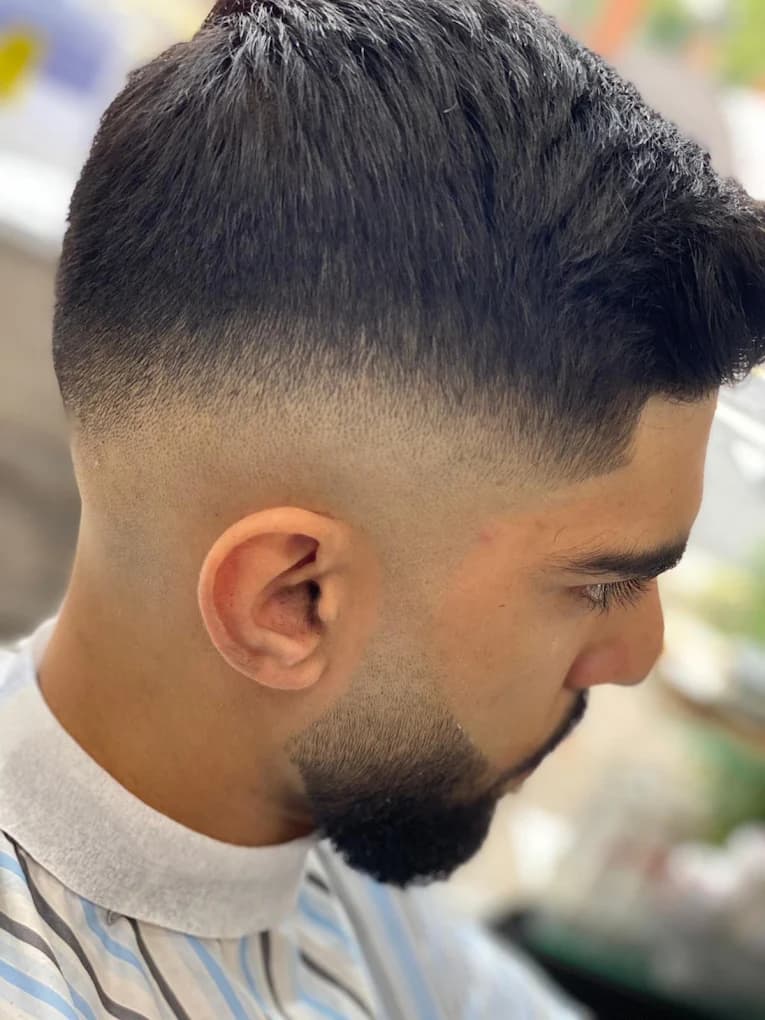 Mid skin fade with textured top and sharp beard line-up