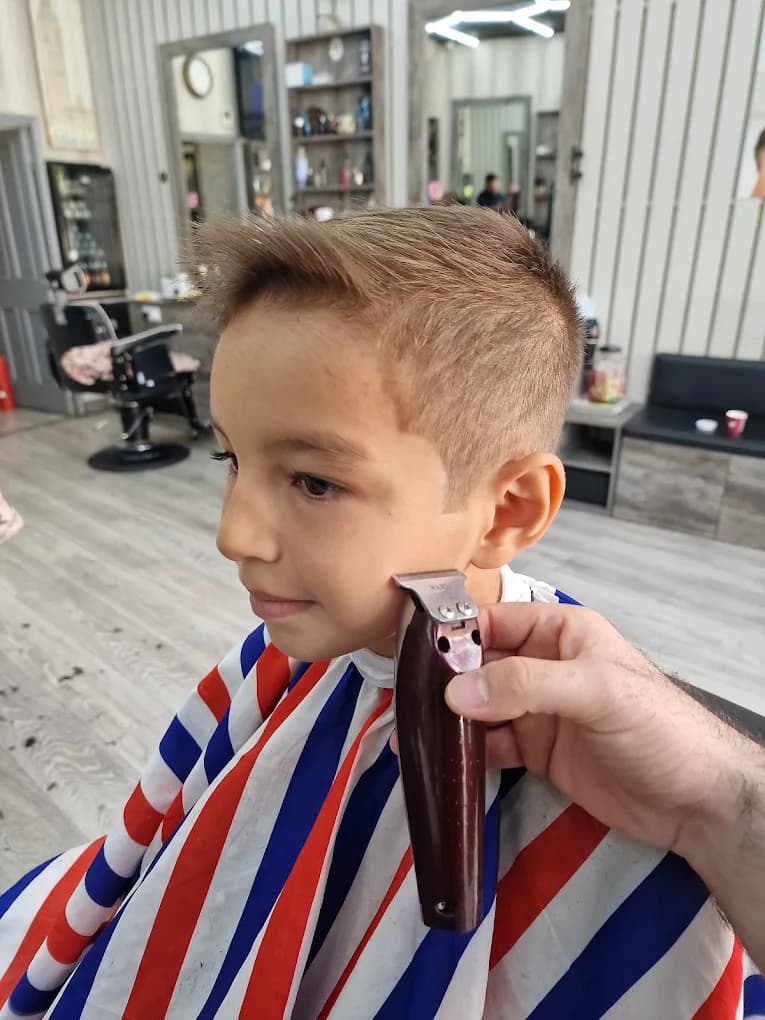 Junior side-part haircut with a clean taper and textured fringe